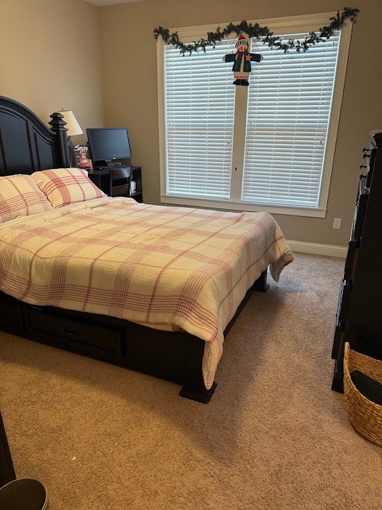 After — a made bed with a plaid comforter, a clear carpet and a lamp on the nightstand, guest bedroom in Union, KY