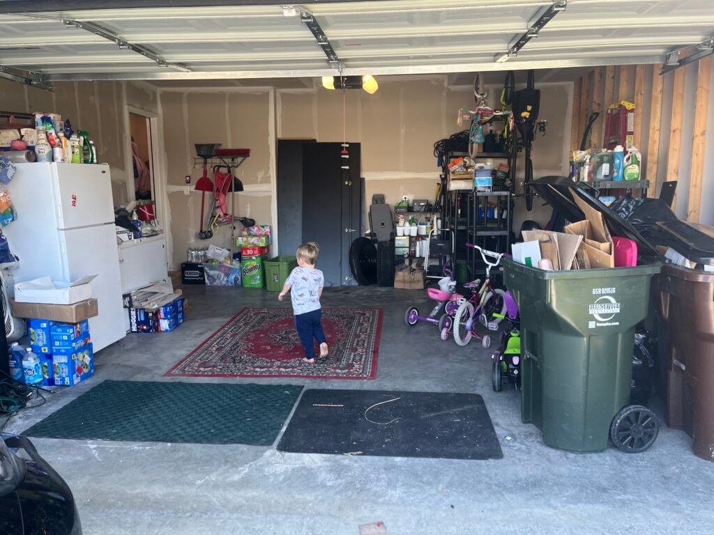 After — a cleared garage floor with a rug in the middle, bikes lined along the right wall and supplies shelved at the back, garage in Loveland, OH