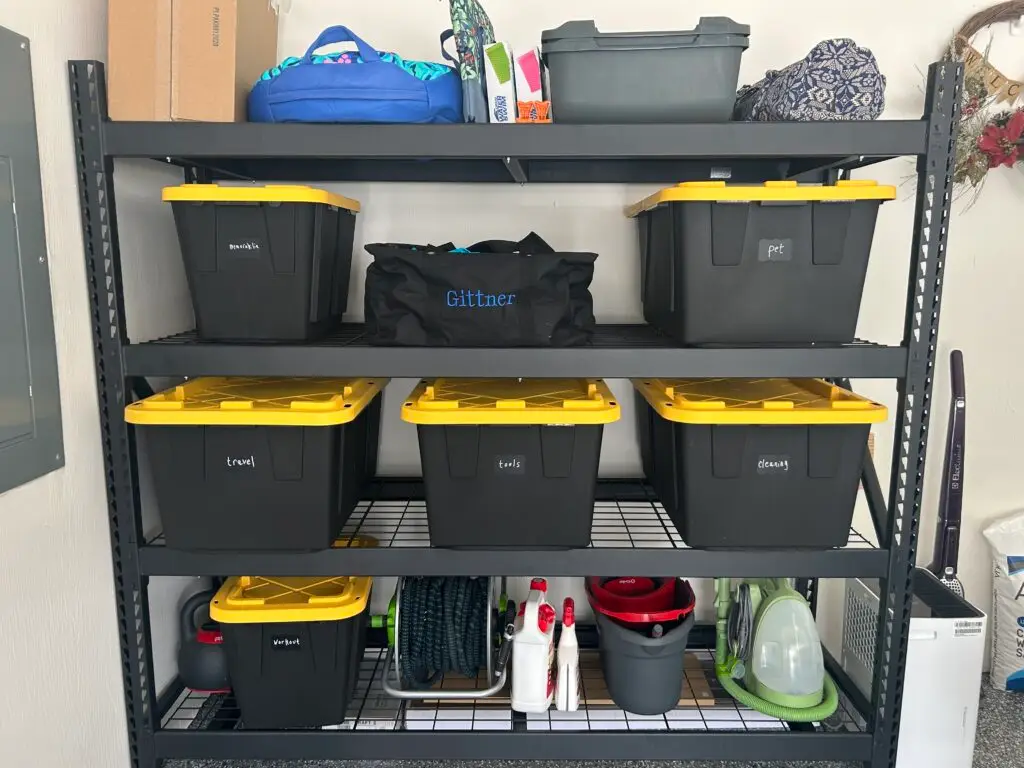 After — shelving with bins labeled decorations, pet, travel, tools, cleaning and workout, with a hose reel and cleaning kit on the bottom shelf, garage in Union, KY