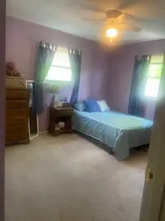 After — a made bed with teal bedding, a styled dresser and a clear carpet, guest bedroom in Cincinnati, OH