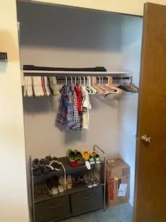 After — clothes spaced on the rail with a shoe rack and drawers below and a clear floor, kids closet in Cincinnati, OH