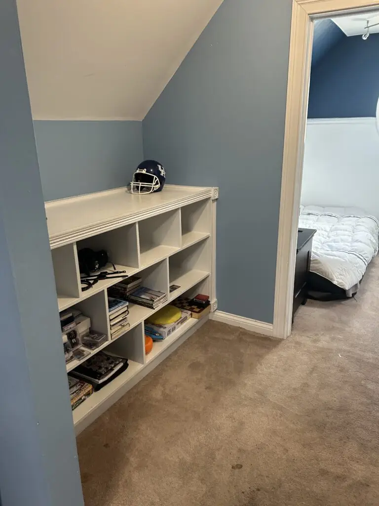 After — the cubby unit with books and games in sections, a football helmet on top and a clear carpet, kids bedroom in Alexandria, KY