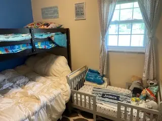 After — a made bunk bed and a made toddler bed with stuffed animals under the window, kids bedroom in Cincinnati, OH
