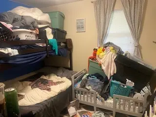 Before — a toddler bed full of toys beside a loaded bunk bed and bins under the window, kids bedroom in Cincinnati, OH