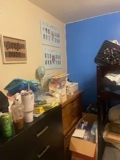 Before — a dresser top covered in cups and papers with boxes on the floor beside it, kids bedroom in Cincinnati, OH