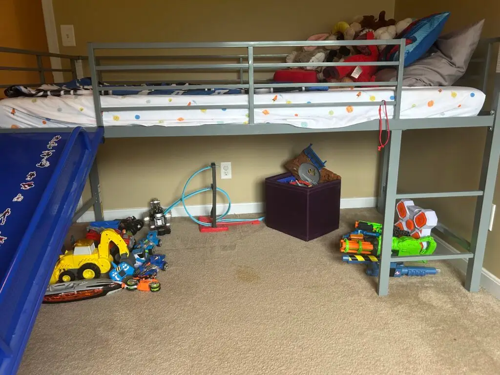 After — toys grouped by type under the loft bed with a fabric storage cube and blasters racked on the frame, boys bedroom in Walton, KY