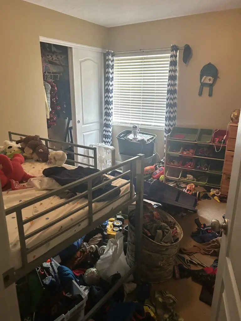 Before — clothes, toys and shoes covering the floor with stuffed animals piled on the loft bed, boys bedroom in Walton, KY