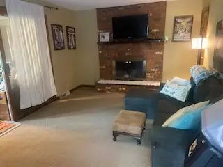 After — a clear carpet, a navy sectional with cushions and the brick fireplace in view, living room in Cincinnati, OH
