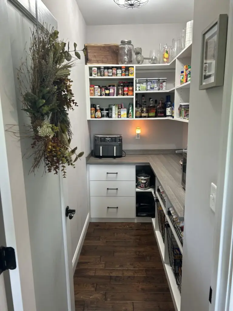 After — grouped shelves, a clear counter and labeled wire baskets on the lower shelf, walk-in pantry in Demossville, KY